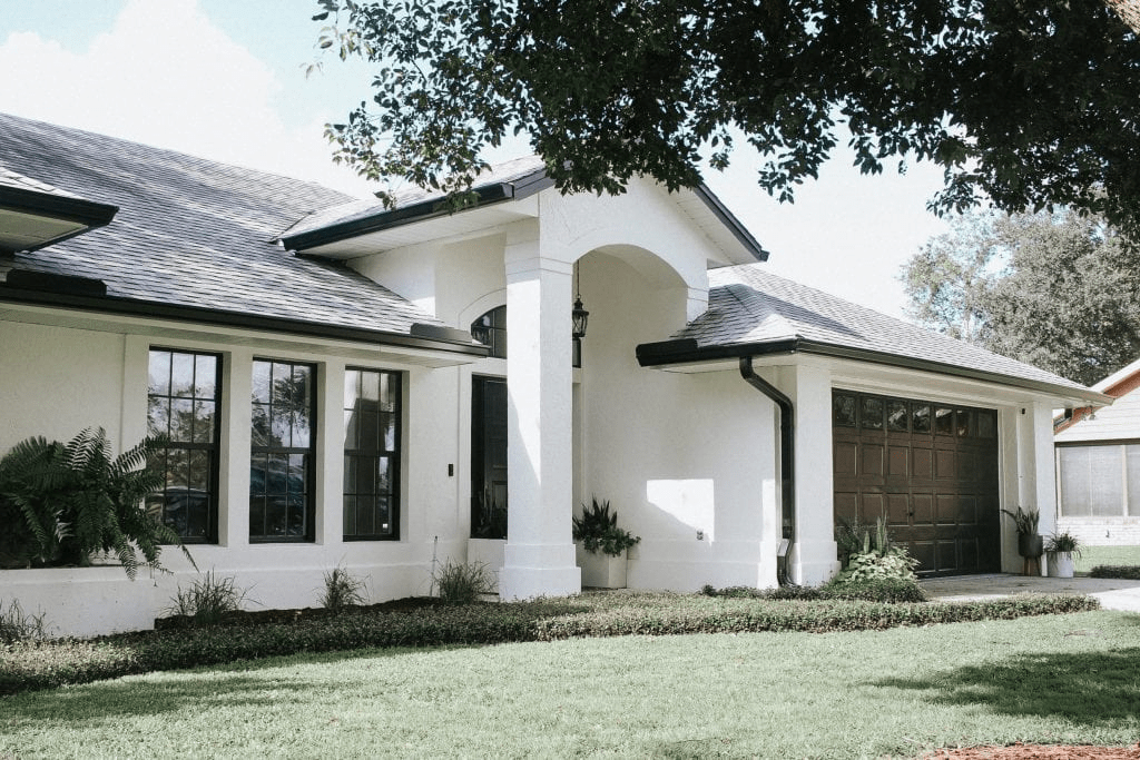 White Brick Ranch House With Dark Grey Roof, Gutters & Shutters