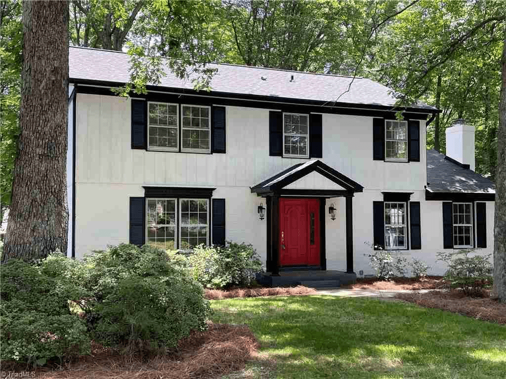 White House With Black Roof And Shutter With Red Door